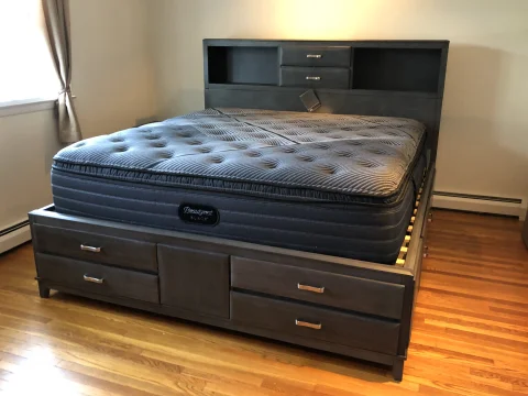 Grey and white pillow-top mattress on a bed frame